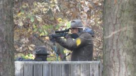 Ein Jäger zielt zum Schießen vom Hochstand.