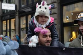 Kind mit Stofftier auf den Schultern eines Mannes.
