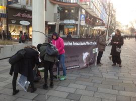 AktivistInnen mit Protestbanner und InteressentInnen