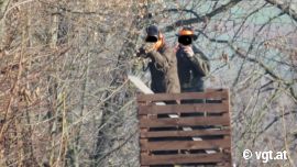 Jäger zielt mit Gewehr auf Tierschützer