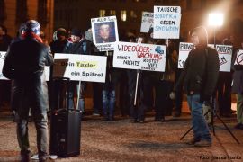 Rede vor der demonstrierenden Personengruppe und Medienvertretern.