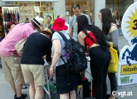 Passant_innen scharren sich um einen Infotisch