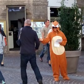 Eine als Fuchs verkleidete Aktivistin verteilt Flugblätter