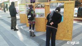 Passant_innen studieren die Ausstellungsplakate