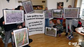 Aktivist_innen halten Banner und Bilder