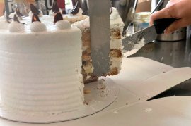 Die vegane Sahnetorte Torte wird angeschnitten.