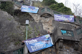 Aktivist:innen zeigen Banner am Schlossbreg in Graz